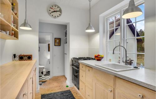 una cucina con lavandino e orologio sul muro di Beautiful Home In Rrvig With Kitchen a Rørvig