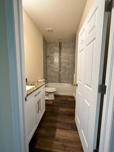 a bathroom with a toilet and a sink and a tub at getAway Home in Lehigh Acres