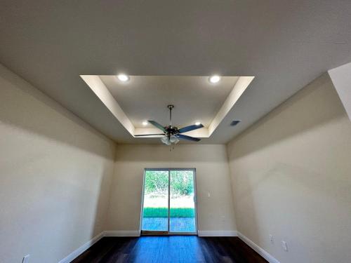 an empty room with a ceiling fan and a window at getAway Home in Lehigh Acres