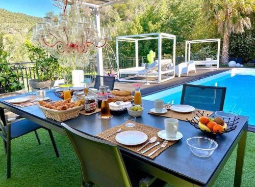 una mesa azul con comida junto a una piscina en VILLA COLINA, en Mandelieu-la-Napoule