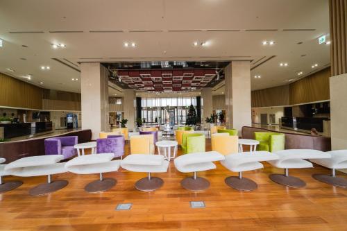 a lobby with white chairs and colorful seating at Ocean Star Leisure Condo in Seogwipo