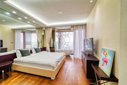 een slaapkamer met een bed en een bad in een kamer bij Ocean Star Leisure Condo in Seogwipo
