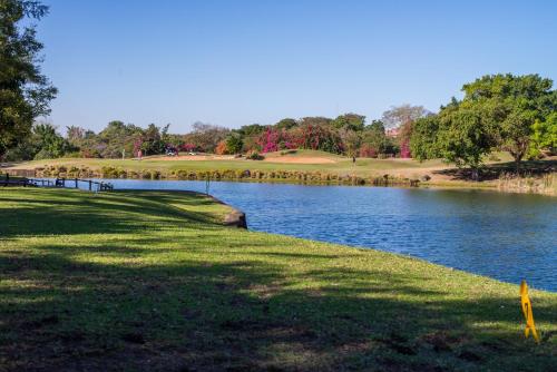 a golf course with a lake in the foreground at Kruger Park Lodge Unit No. 241 in Hazyview
