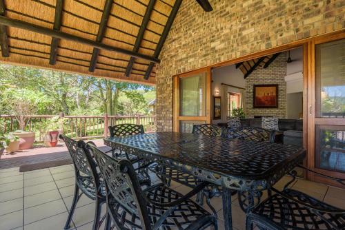a dining room with a table and chairs on a patio at Kruger Park Lodge Unit No. 241 in Hazyview