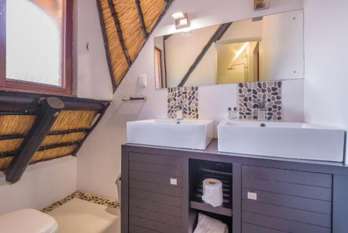 La salle de bains est pourvue de 2 lavabos et d'un miroir. dans l'établissement Kruger Park Lodge Unit No. 241, à Hazyview