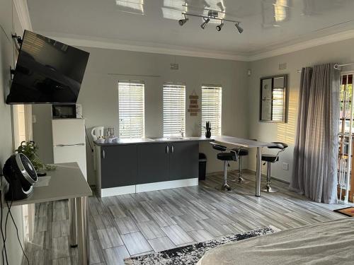 a living room with a kitchen and a table with chairs at 22 on Mirabel in Kempton Park