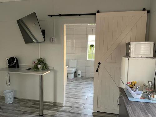 a kitchen with a door open to a bathroom with a refrigerator at 22 on Mirabel in Kempton Park