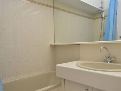 une salle de bain avec un lavabo, une baignoire et un miroir dans l'établissement Cap d'Agde : T2 avec piscine, parking, à 50m de la plage - FR-1-249-71, au Cap d'Agde