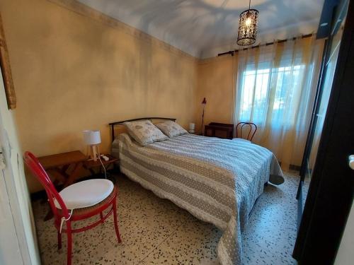 une chambre avec un lit, une chaise et une fenêtre dans l'établissement Appartement 3 pièces RDC 8 pers avec Terrasse et Confort Modeste - FR-1-326-738, à Marseillan