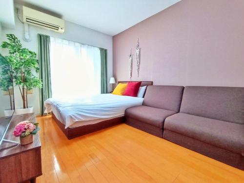 a living room with a couch and a bed at Picoro Hakata - Vacation STAY 11333 in Fukuoka