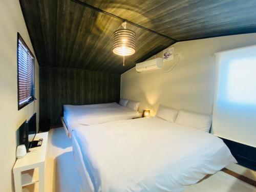 Kleines Zimmer mit 2 Betten und einem TV in der Unterkunft Namba Tsutenkaku High Class Villa in Osaka
