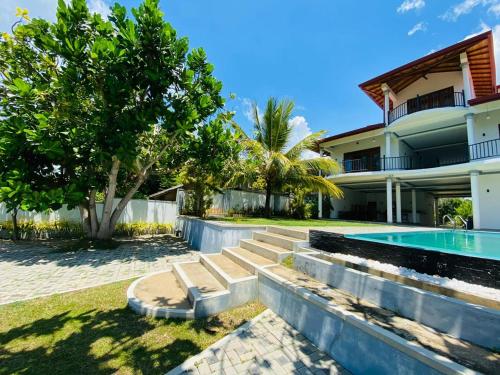 a house with a swimming pool next to a house at Villa Riverside in Aluthgama