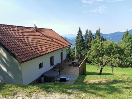 a small white house with a wooden deck at Cottage Planska koča in Vitanje