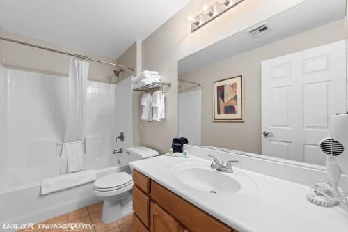 a white bathroom with a sink and a toilet at Hawk Ridge Two Bedroom Condo by Cool Properties in Mesquite