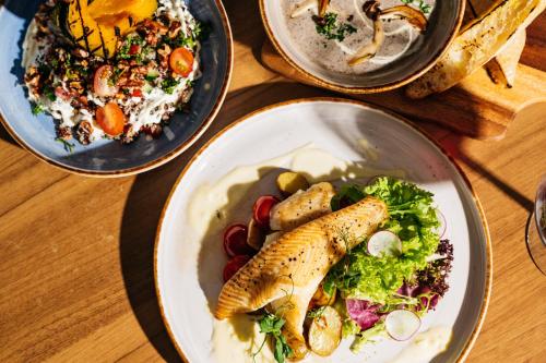 a table with three plates of food with fish and salad at Mercure Singapore Tyrwhitt in Singapore