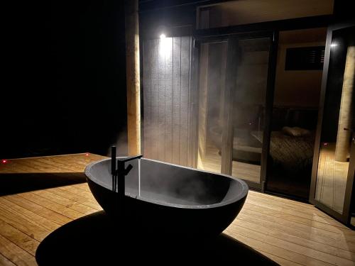 a bath tub sitting on a wooden floor in a room at Pukeko Lane in Tauranga