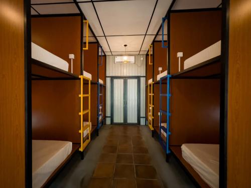 a corridor of a dorm room with bunk beds at Lost & Found Hostel Weligama in Weligama