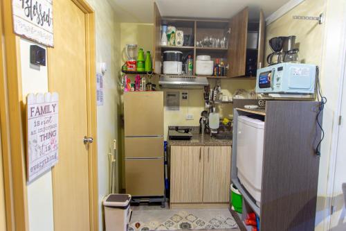 a small kitchen with a refrigerator and a sink at Pandora’s Nest in Manila
