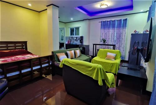 a room with two beds and two green chairs at Lovely Casa 