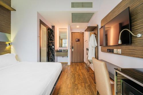 a hotel room with a bed and a bathroom at Mercure Singapore Tyrwhitt in Singapore