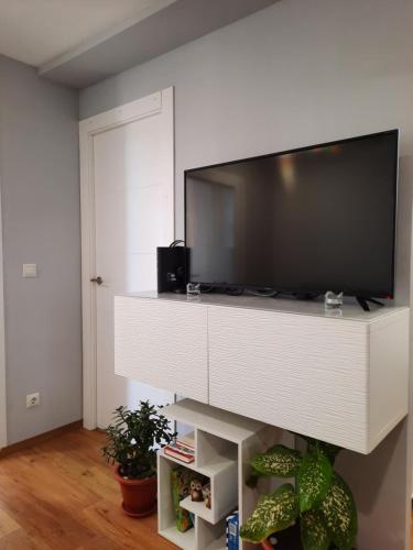 salon z telewizorem z płaskim ekranem w białym centrum rozrywki w obiekcie Sunshiny Costa del Sol - BEACH APARTMENT w mieście Fuengirola