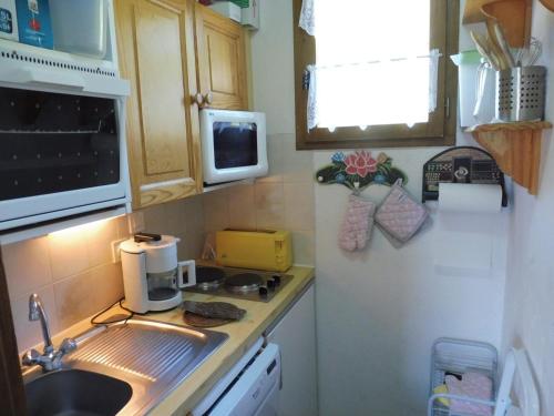 une petite cuisine avec un évier et un micro-ondes dans l'établissement Appartement duplex cosy à Crest-Voland, 6 pers, proche pistes et garage inclus - FR-1-595-72, à Crest-Voland