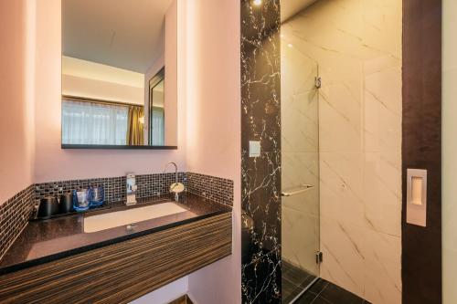 a bathroom with a sink and a shower at Mercure Singapore Tyrwhitt in Singapore