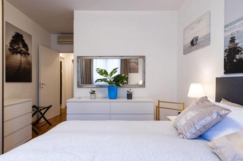 una camera con un letto bianco e una finestra di Wraparound Lake Views Bellavista Residence a Campione dʼItalia