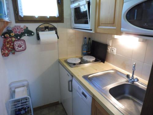 une petite cuisine avec un évier et un micro-ondes dans l'établissement Appartement duplex cosy, 6 pers, proche pistes, garage privé, Crest-Voland - FR-1-595-73, à Crest-Voland