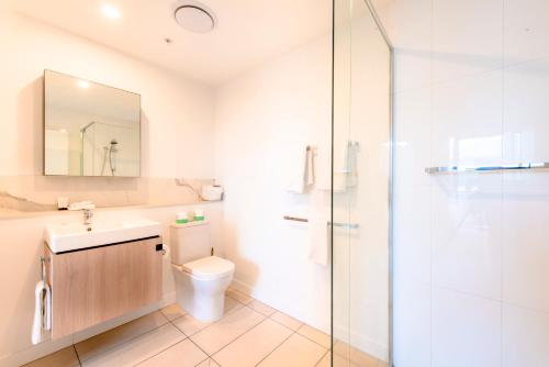 a bathroom with a toilet and a sink and a shower at Hope Street Apartments by CLLIX in Brisbane