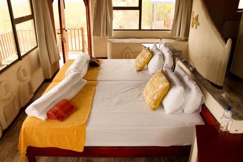 Una cama en una habitación con almohadas. en Ugab Terrace Lodge, en Fingerklippe 