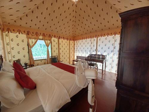 a bedroom with a bed in a room with wallpaper at Hotel Green Haveli - A Heritage and Hill View Hotel , Pushkar in Pushkar