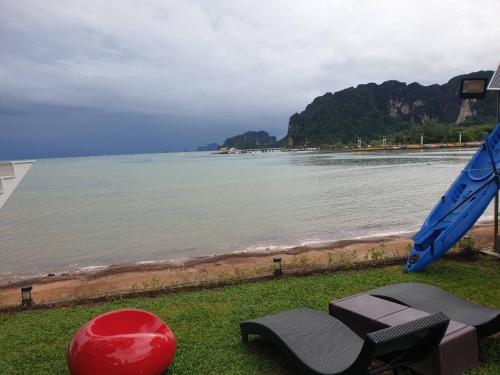 a view of a beach with two chairs and a red ball at Blue Orchid Beach Krabi - SHA Certified in Ao Nam Mao