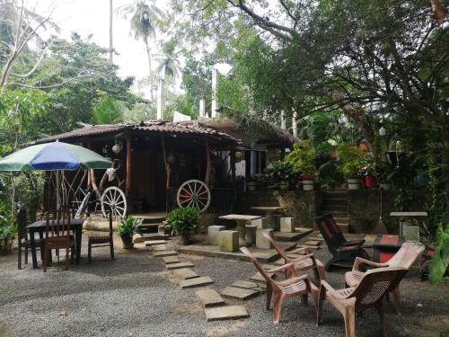 a house with a horse drawn carriage and chairs at Sea Breeze Garden in Tangalle