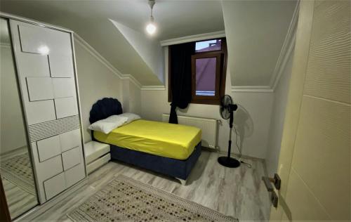 Un pequeño dormitorio con una cama amarilla y una ventana en Full floor in duplex apartment, en Avcılar