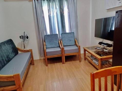 - un salon avec un canapé, des chaises et une télévision dans l'établissement The Loop High Rise Condominium in CDO, à Cagayán de Oro
