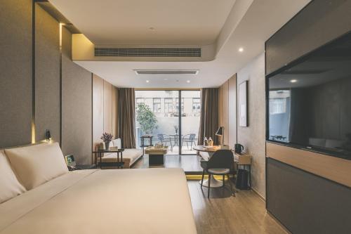 um quarto de hotel com uma cama e uma sala de estar em Atour Hotel East Nanjing Road Near The Bund em Xangai