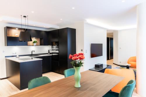 a kitchen and dining room with a vase of flowers on a table at Suite Romanée 6 personnes vue Cathédrale 2 Places de parking in Dijon