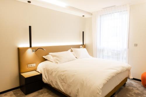a bedroom with a large white bed with a window at Suite Romanée 6 personnes vue Cathédrale 2 Places de parking in Dijon