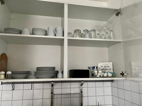 kuchnia z talerzami i naczyniami na półkach w obiekcie Ferienwohnung Falkenstr. w mieście Enger