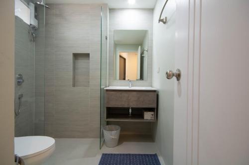 ein Bad mit einer Dusche, einem Waschbecken und einem WC in der Unterkunft Mantra Beach condominium M116,M140 in Ban Phlong Sawai