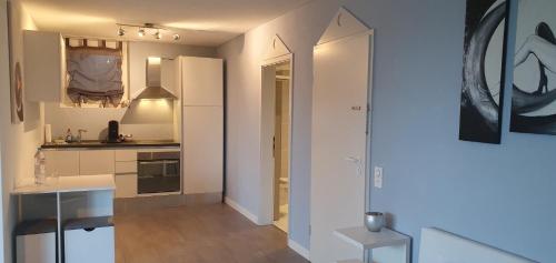 a kitchen with white cabinets and a table in it at Ferienwohnung am Bodensee mit Seesicht und Wellness in Rorschacherberg