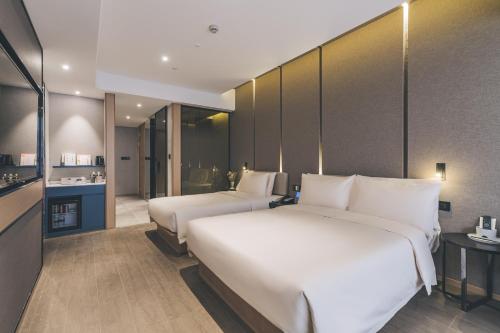 a hotel room with two beds and a kitchen at Shanghai Atour Hotel On The Bund- People Square in Shanghai