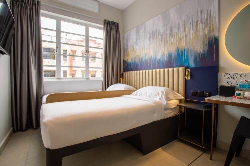 a hotel room with a bed and a window at ibis budget Singapore Gold in Singapore