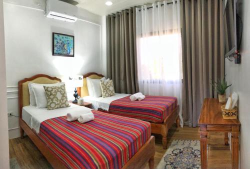 a hotel room with two beds and a window at Villa Lydia y Jose Heritage Hotel in Bayubay Sur