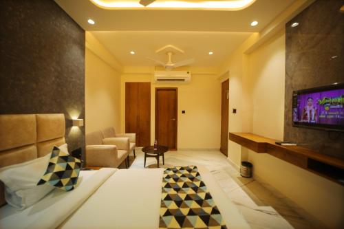 a hotel room with a bed and a tv at The Sky Imperial Hotel Sugam - 10 Meters from Shrinathji Temple in Nāthdwāra