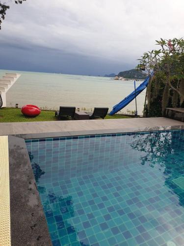 a swimming pool with a view of the ocean at Blue Orchid Beach Krabi - SHA Certified in Ao Nam Mao