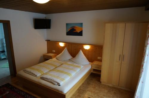 1 dormitorio con 1 cama y TV en la pared en Erbhof Innertal, en Tux