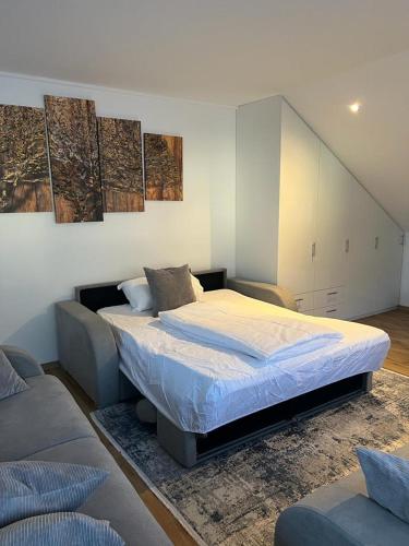 a bedroom with a large bed and a couch at Ferienwohnung Alpina in Feldkirch