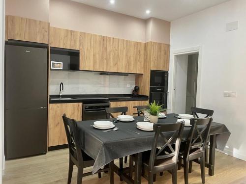 Un comedor con mesa y sillas y una cocina. en UIM Mediterraneo PB Luis Vives Wifi, en Puerto Sagunto